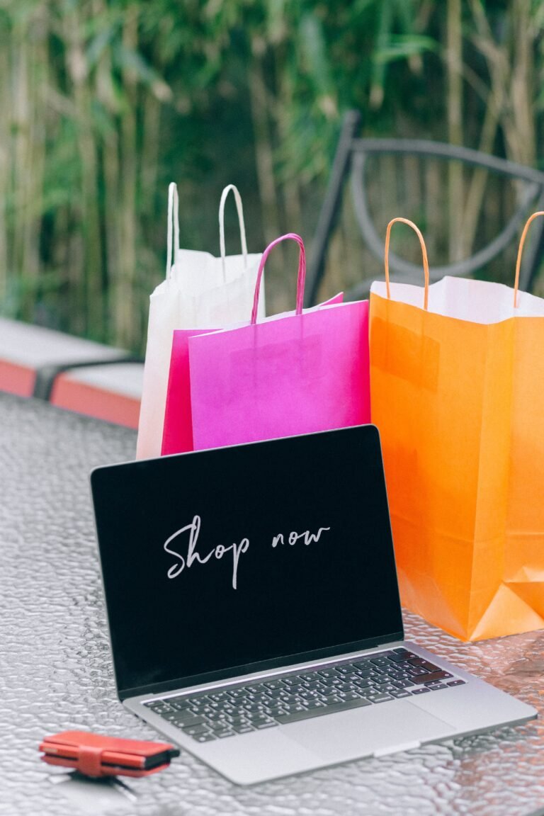 Laptop next to paper shopping bags representing an online store order