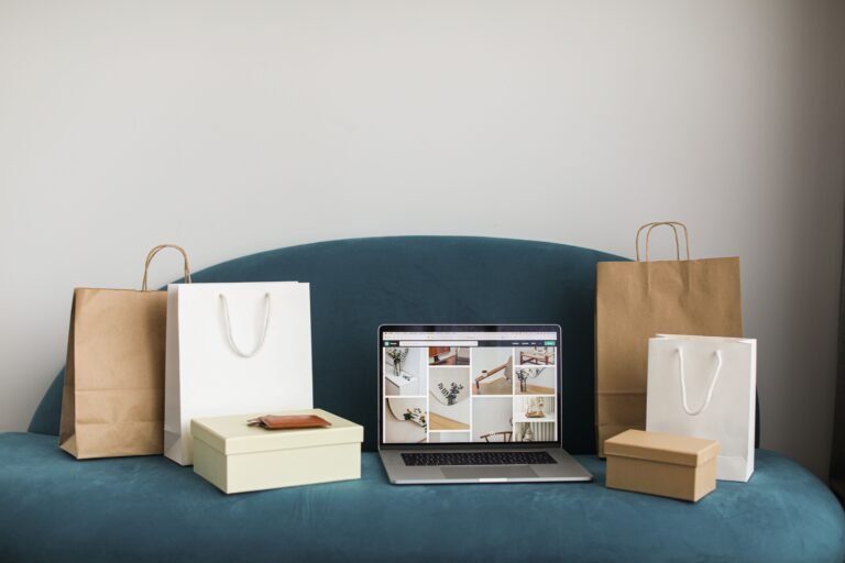 Laptop surrounded by shopping bags and boxes, representing online store fulfillment