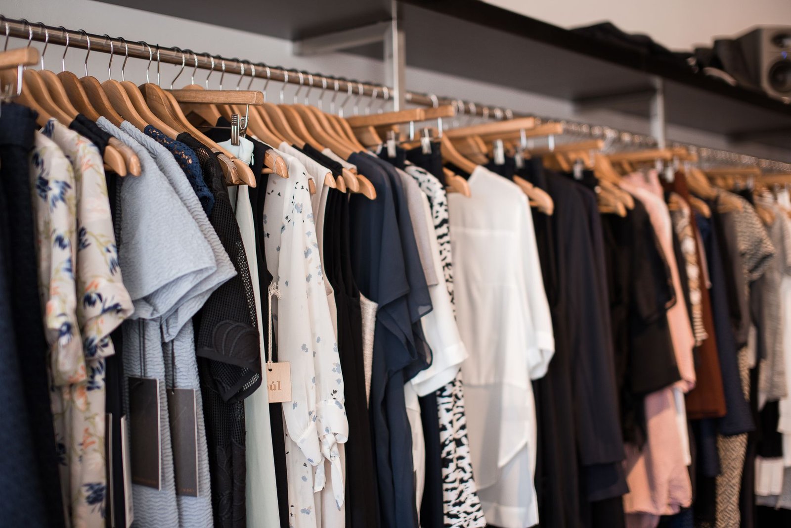 Vibrant boutique clothing collection displayed on wooden hangers